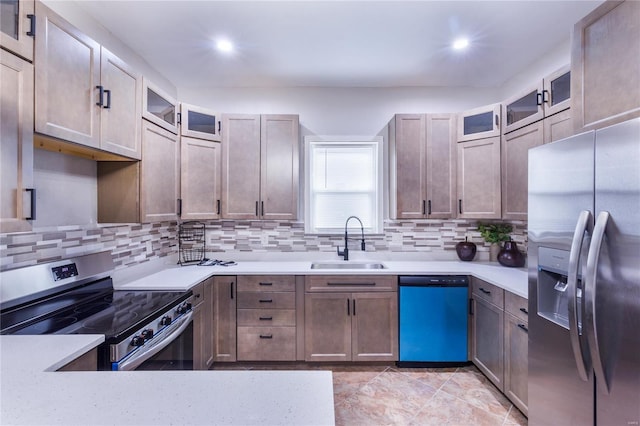 kitchen featuring light countertops, a sink, backsplash, and stainless steel appliances