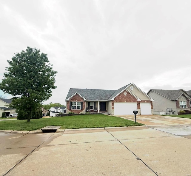 view of front of property with brick siding, driveway, a front yard, and a garage