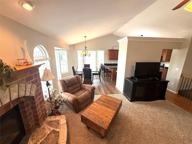 living area featuring ceiling fan, a fireplace, wood finished floors, baseboards, and lofted ceiling