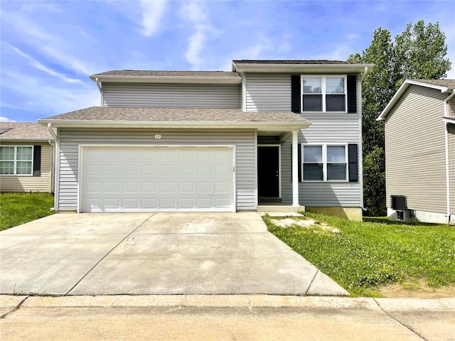 traditional home with a garage, central air condition unit, and driveway