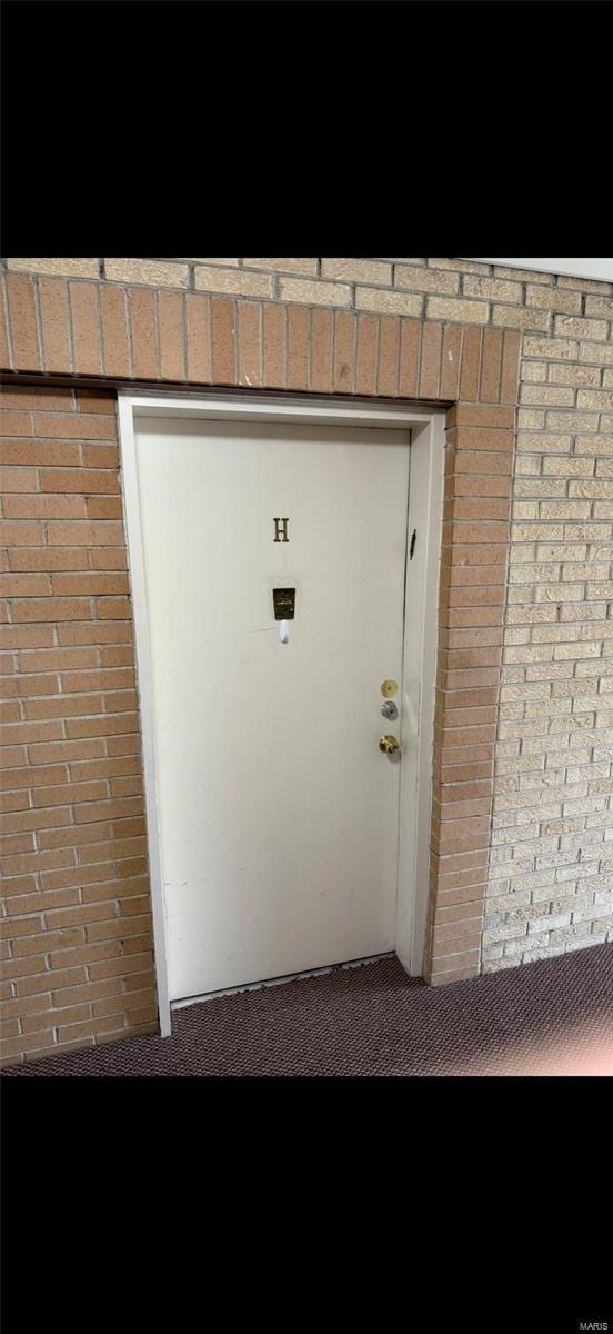 entrance to property featuring brick siding