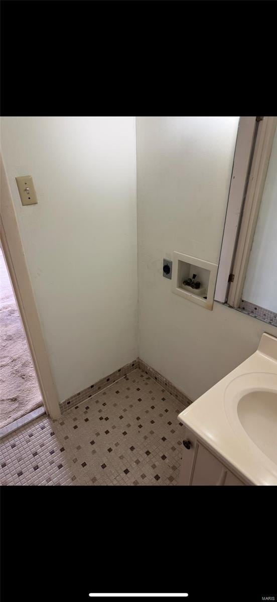 washroom with a sink, electric dryer hookup, washer hookup, and light floors