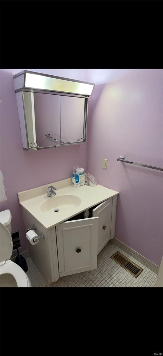 bathroom featuring vanity, toilet, and visible vents
