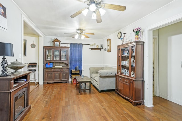 living area with a ceiling fan and hardwood / wood-style flooring