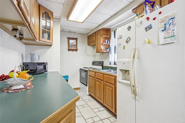 kitchen featuring white refrigerator with ice dispenser, electric range oven, a paneled ceiling, a toaster, and glass insert cabinets