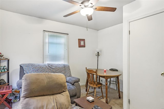 living area featuring baseboards, ceiling fan, and carpet flooring