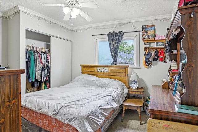 bedroom featuring a closet, ornamental molding, carpet flooring, a textured ceiling, and a ceiling fan