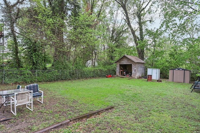 view of yard with fence, an outdoor structure, and a shed