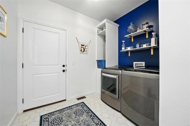 clothes washing area with washer and dryer, laundry area, visible vents, and baseboards