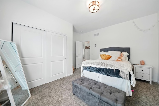 carpeted bedroom with visible vents, baseboards, and a closet