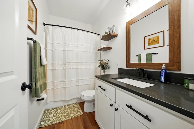 bathroom featuring vanity, wood finished floors, and toilet