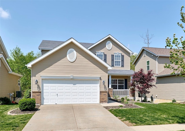 traditional home featuring covered porch, driveway, a garage, brick siding, and a front lawn