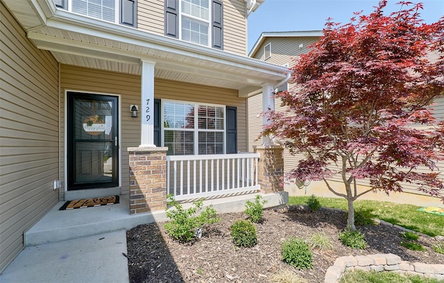 property entrance with a porch and stone siding