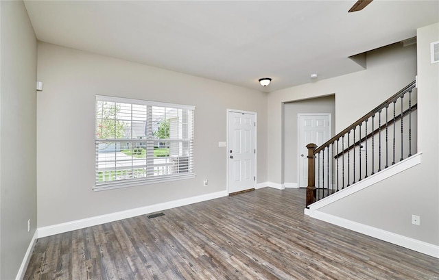 entryway featuring visible vents, baseboards, wood finished floors, and stairway