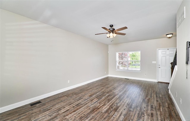 empty room featuring baseboards, a ceiling fan, dark wood-style floors, and visible vents