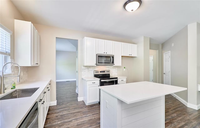 kitchen featuring appliances with stainless steel finishes, baseboards, decorative backsplash, and dark wood-style flooring