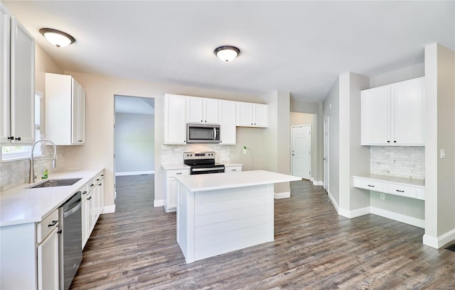 kitchen featuring stainless steel appliances, baseboards, decorative backsplash, and a sink