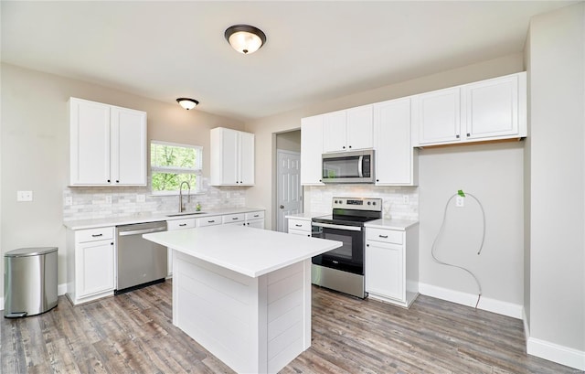 kitchen featuring a sink, light countertops, stainless steel appliances, white cabinetry, and tasteful backsplash