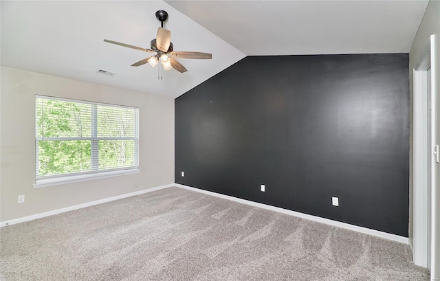 carpeted empty room with ceiling fan, visible vents, baseboards, and lofted ceiling
