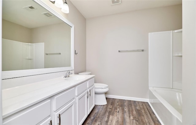 bathroom featuring vanity, toilet, wood finished floors, and visible vents