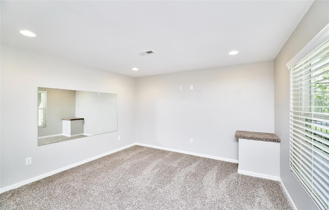 carpeted empty room featuring recessed lighting, baseboards, and visible vents