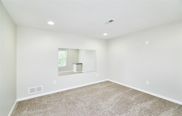 spare room featuring visible vents, carpet flooring, and baseboards
