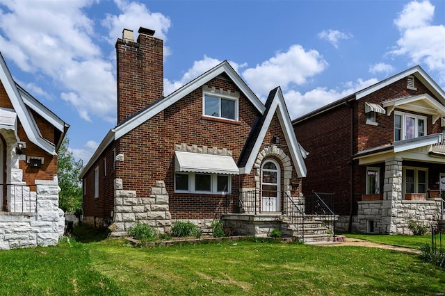 view of front of property with stone siding, brick siding, a chimney, and a front yard