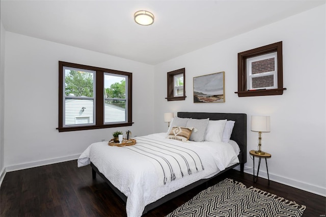 bedroom featuring baseboards and dark wood-type flooring