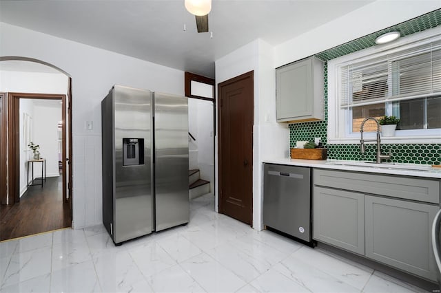 kitchen featuring a sink, gray cabinets, marble finish floor, and stainless steel appliances
