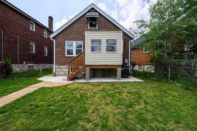 rear view of property featuring fence, a yard, a patio area, and brick siding
