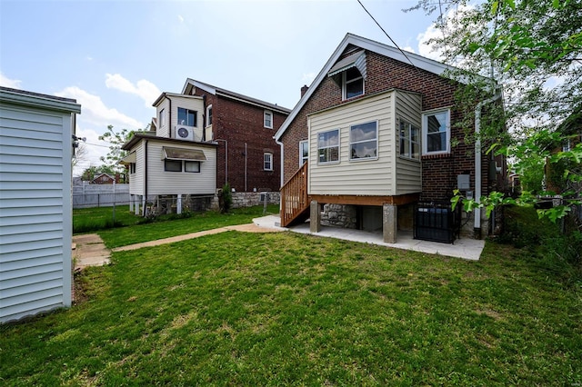 back of house with fence, a yard, and brick siding