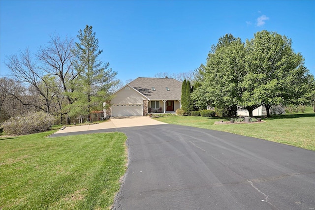 view of front of house featuring driveway, a front yard, and a garage