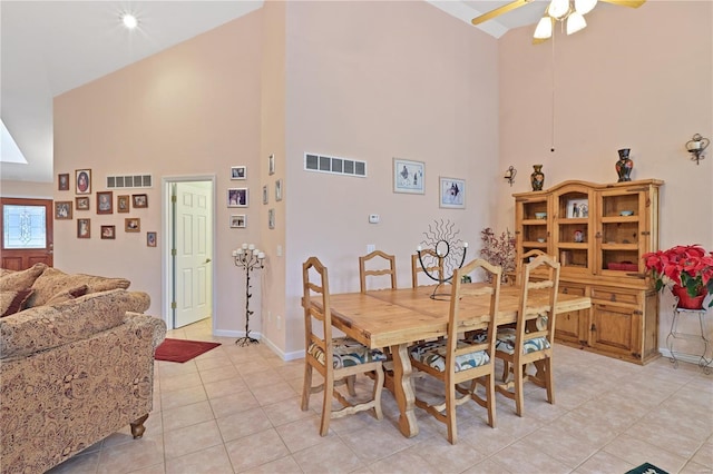 dining area featuring ceiling fan, a high ceiling, visible vents, and light tile patterned floors