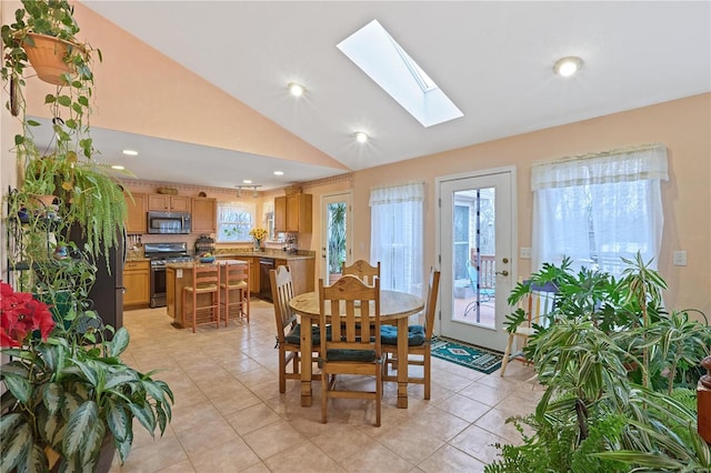 dining area featuring light tile patterned flooring, recessed lighting, and lofted ceiling with skylight
