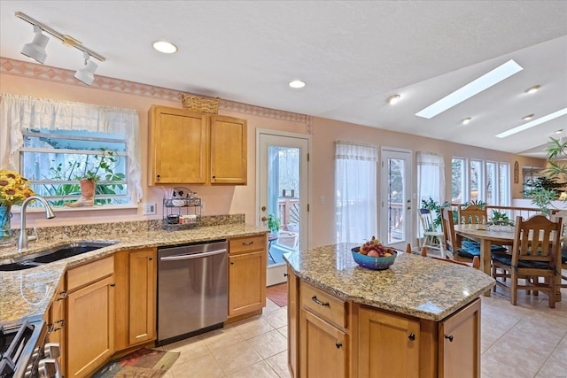 kitchen featuring light tile patterned flooring, stove, a center island, a sink, and dishwasher