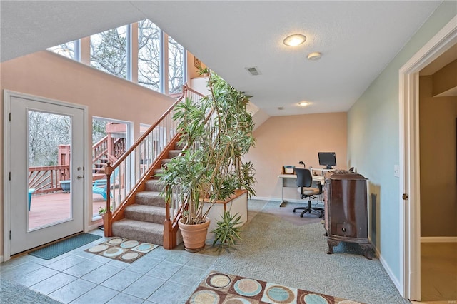 office area featuring a textured ceiling, baseboards, visible vents, and vaulted ceiling