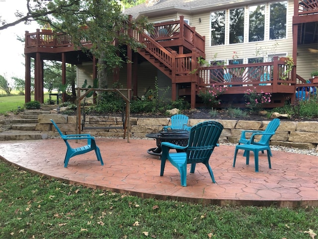 view of play area featuring stairs, a fire pit, a patio area, and a deck