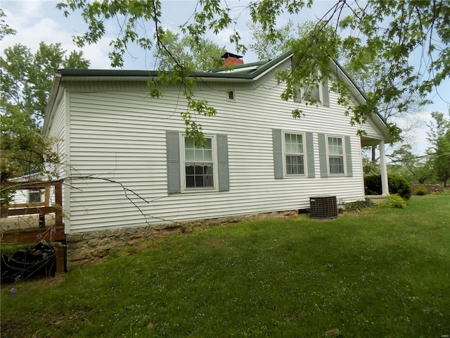 rear view of property featuring a lawn, central AC, and a chimney