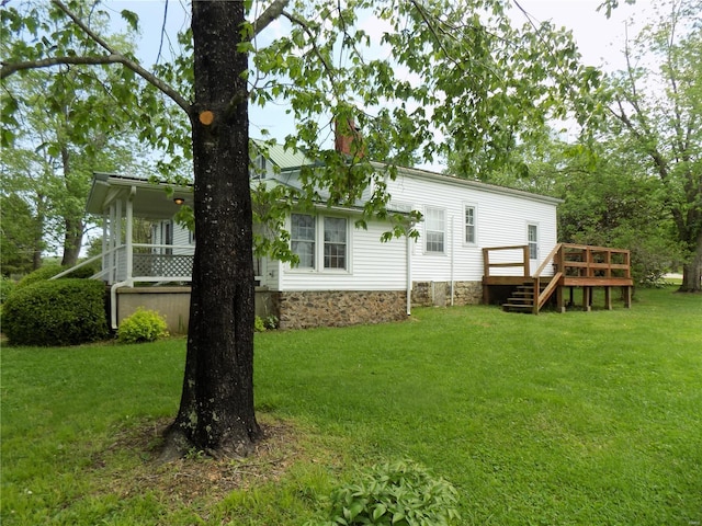 rear view of house with a yard and a deck