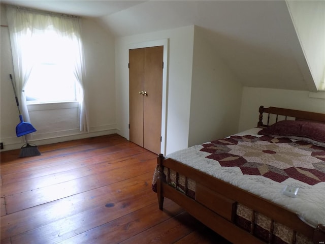 bedroom with wood-type flooring and lofted ceiling