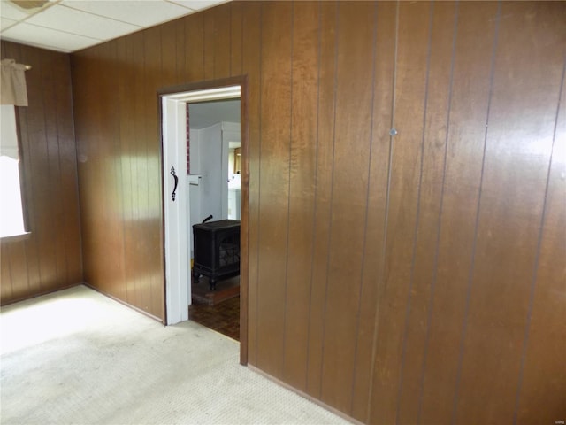 hallway with wooden walls and light colored carpet
