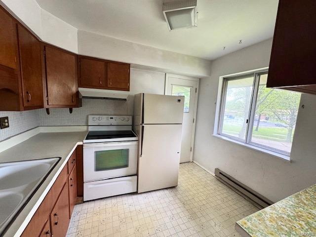 kitchen featuring a sink, light countertops, ventilation hood, light floors, and white appliances