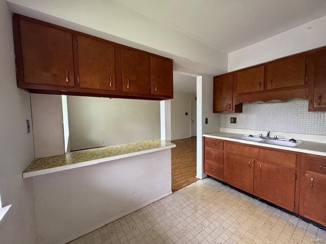 kitchen featuring a sink, light floors, tasteful backsplash, and light countertops