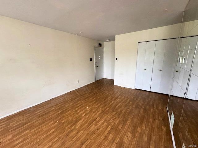 unfurnished bedroom featuring wood finished floors and a closet