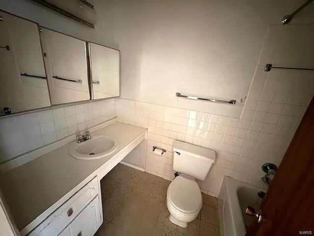 bathroom featuring tile walls, vanity, and toilet