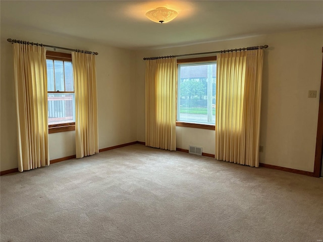 carpeted empty room with baseboards and visible vents