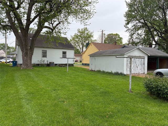 view of yard with central air condition unit and an outbuilding