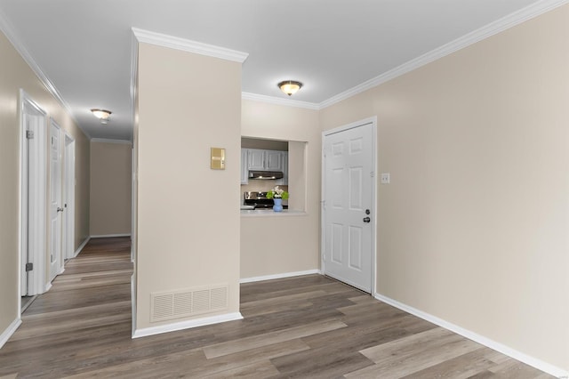 entrance foyer with visible vents, ornamental molding, baseboards, and wood finished floors