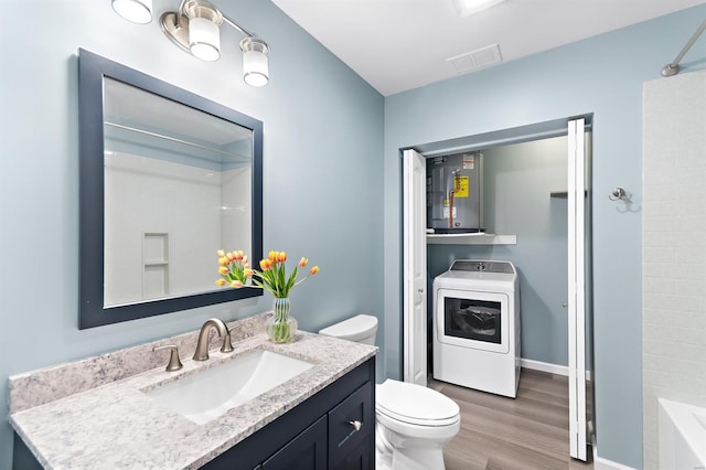 full bathroom featuring vanity, toilet, washer / clothes dryer, wood finished floors, and visible vents