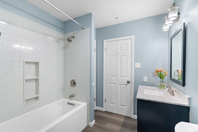 bathroom with washtub / shower combination, baseboards, vanity, and wood finished floors
